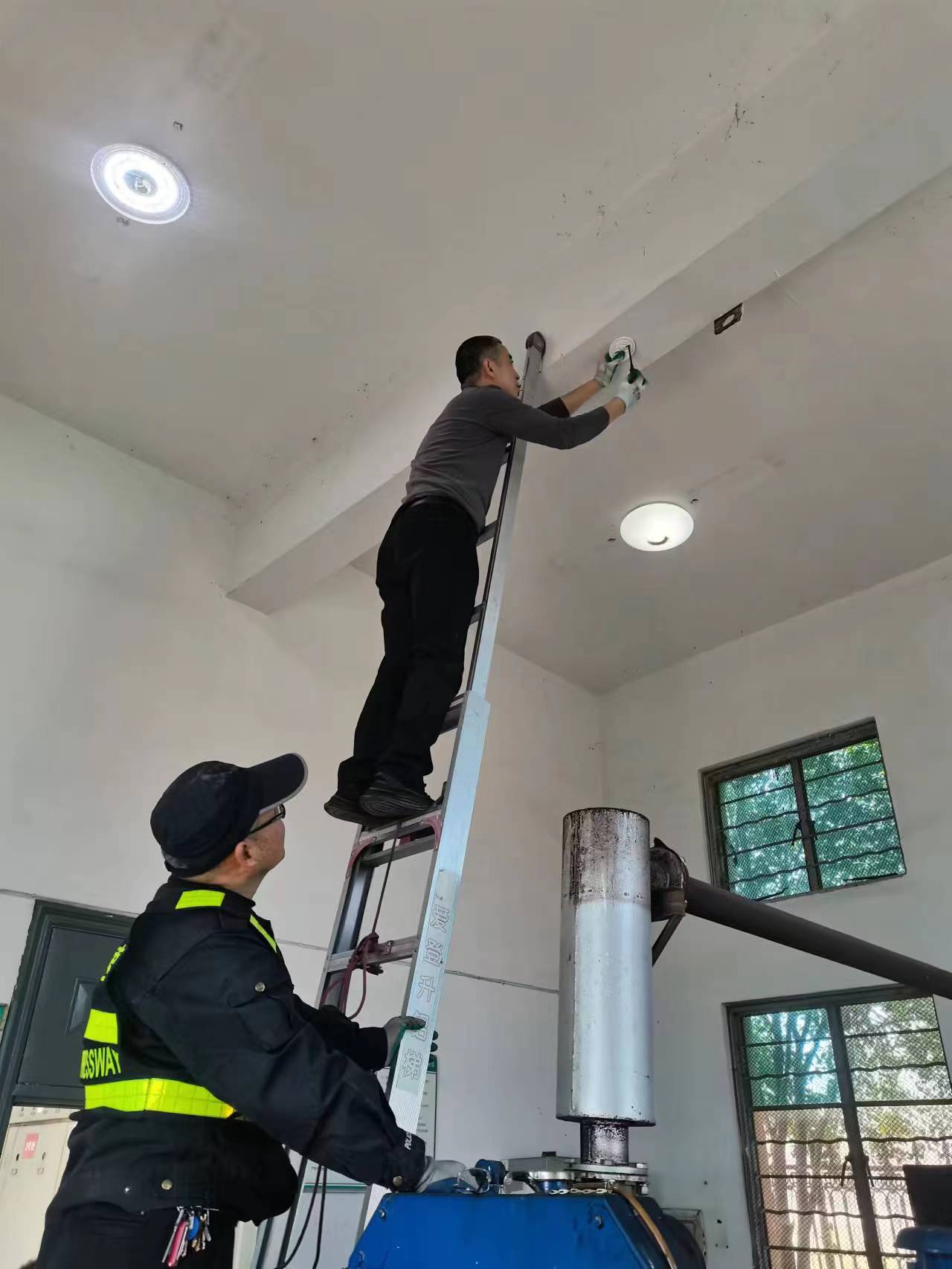 1678315490153790.jpg 工作人員在安裝煙霧報(bào)警器.jpg